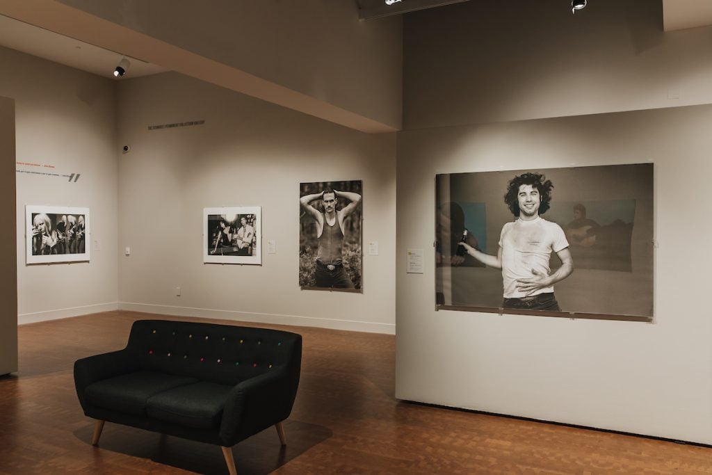 Interior of the Museum of Photographic Arts featuring large glossy prints in an exhibit with dim lighting at Balboa Park, San Diego