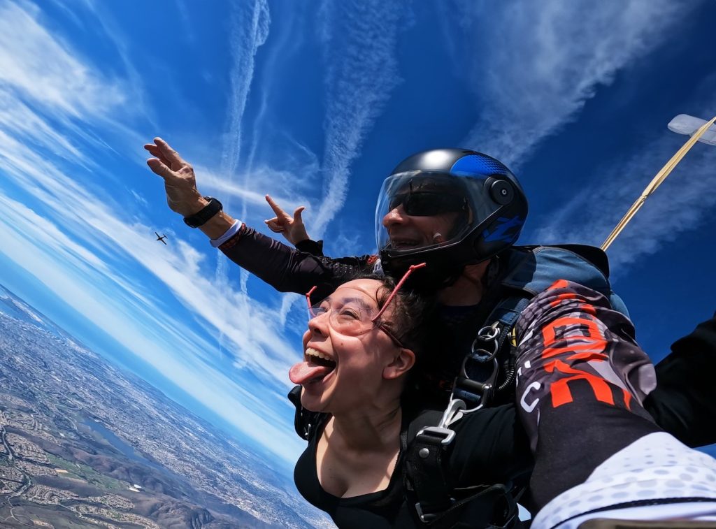 University City High School Nia Hilton with her tongue out while skydiving with an instructor over Otay Lakes 