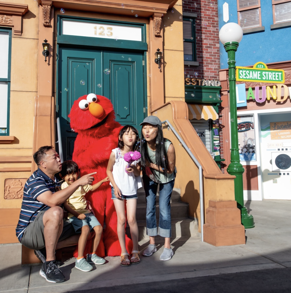 A family taking a picture with elmo at Sesame Place theme park in San Diego, a popular accessible spot for families and disabled people