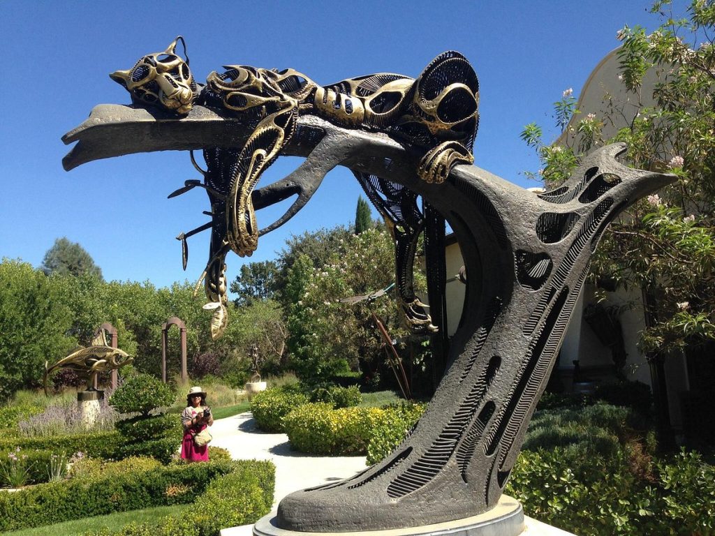 Exterior garden at Sculpterra Winery & Sculpture Garden in Paso Robles, California featuring a large metal statue of a jaguar sleeping on a tree