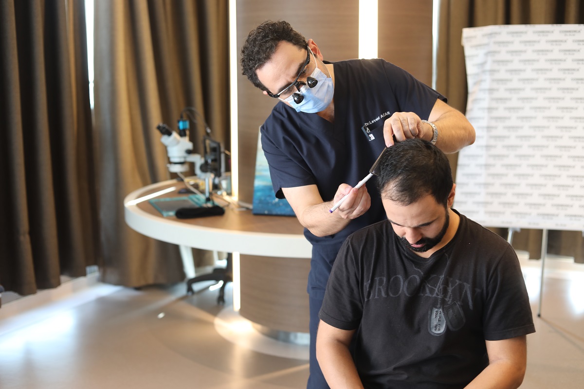Dr. Levent Acar performing a hair analysis at the Cosmedica Clinic in Istanbul, Turkey