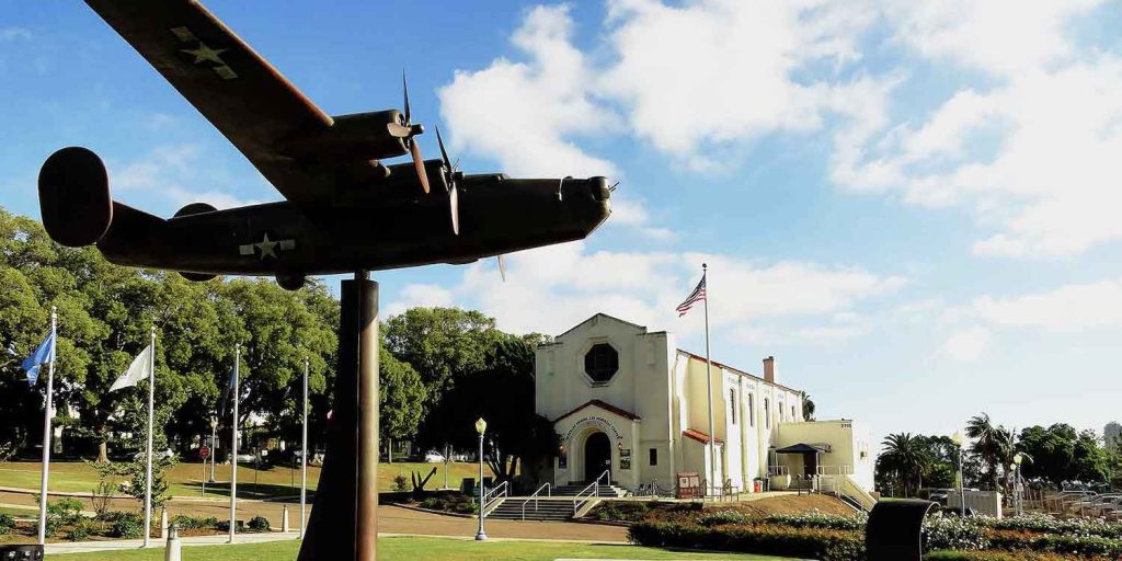 Exterior if The Veterans Museum featuring statue of a WWII plane in front of the building in Balboa Park, San Diego