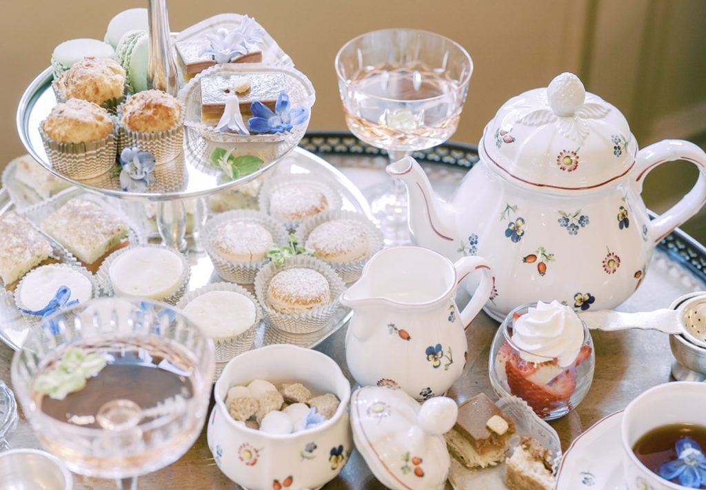 A table full of decorated tea pots, pitchers, pastries, and sweets from the Westgate Hotel's high tea in San Diego
