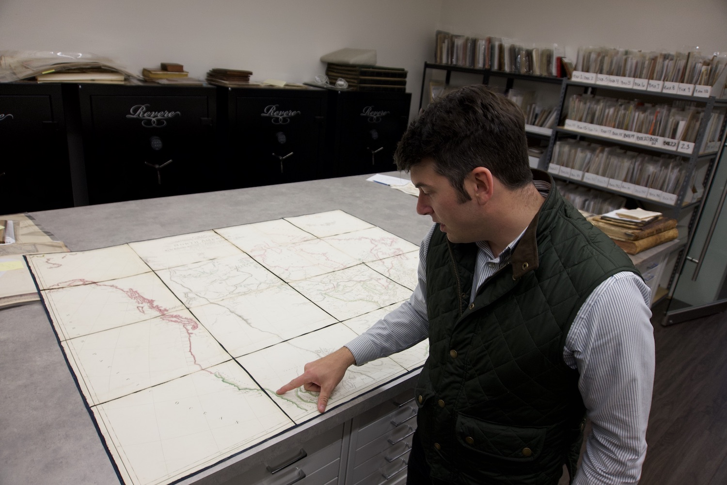Alex Clausen showing a historic map inside Barry Lawrence Ruderman Antique Maps collection in La Jolla, San Diego