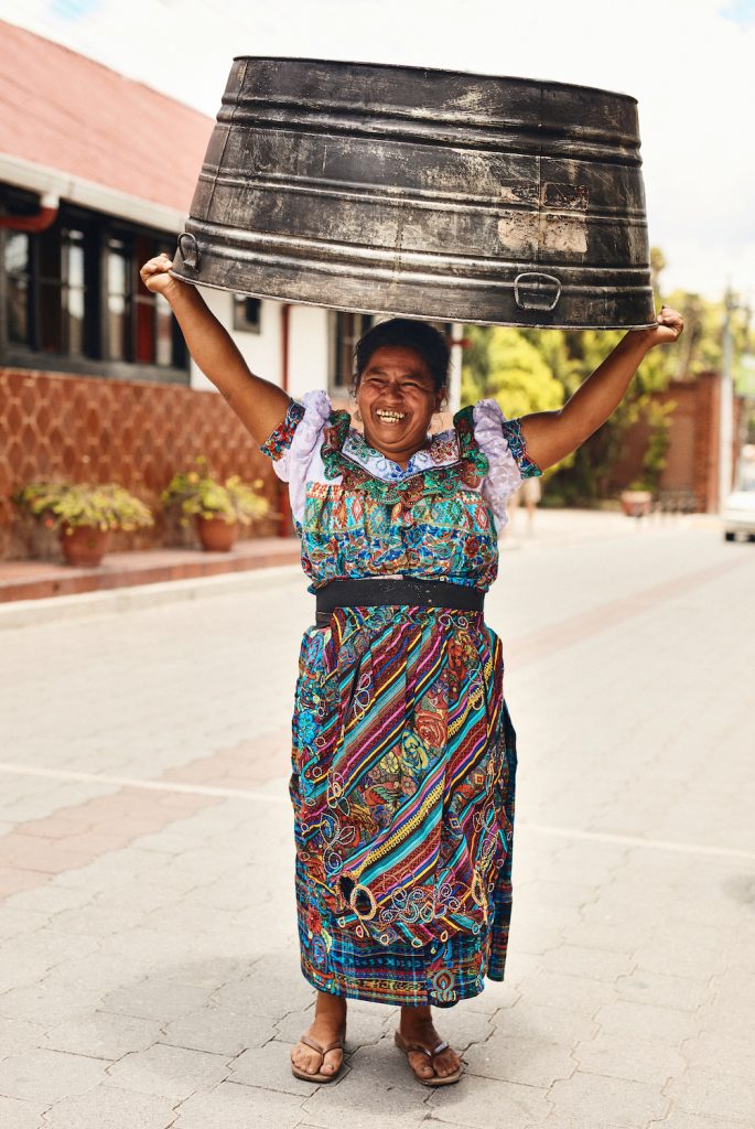 San Diego Photographer Matt Furman's image of an older woman in Guatemala City, Guatemala carrying a large metal bucket over her head