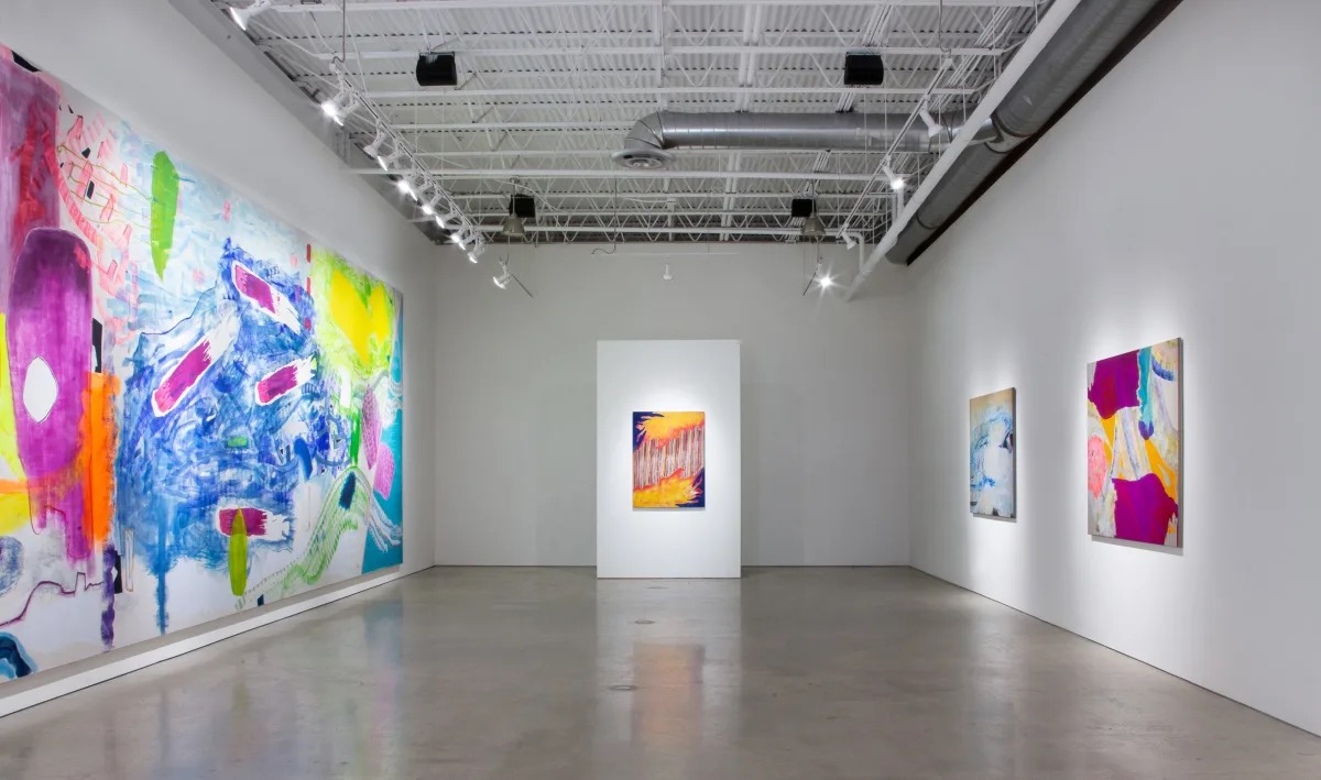 Interior of Quint art gallery in la Jolla, San Diego featuring colorful paintings in a white room