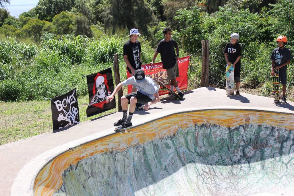 The Roots Skatepark in Kapaau featuring a skateboarder dropping into a bowl on the Big Island of Hawaii 