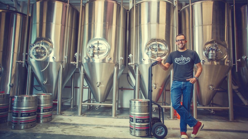 Man in front of brewing casks at Rouleur Brewing Company in Carlsbad, San Diego 