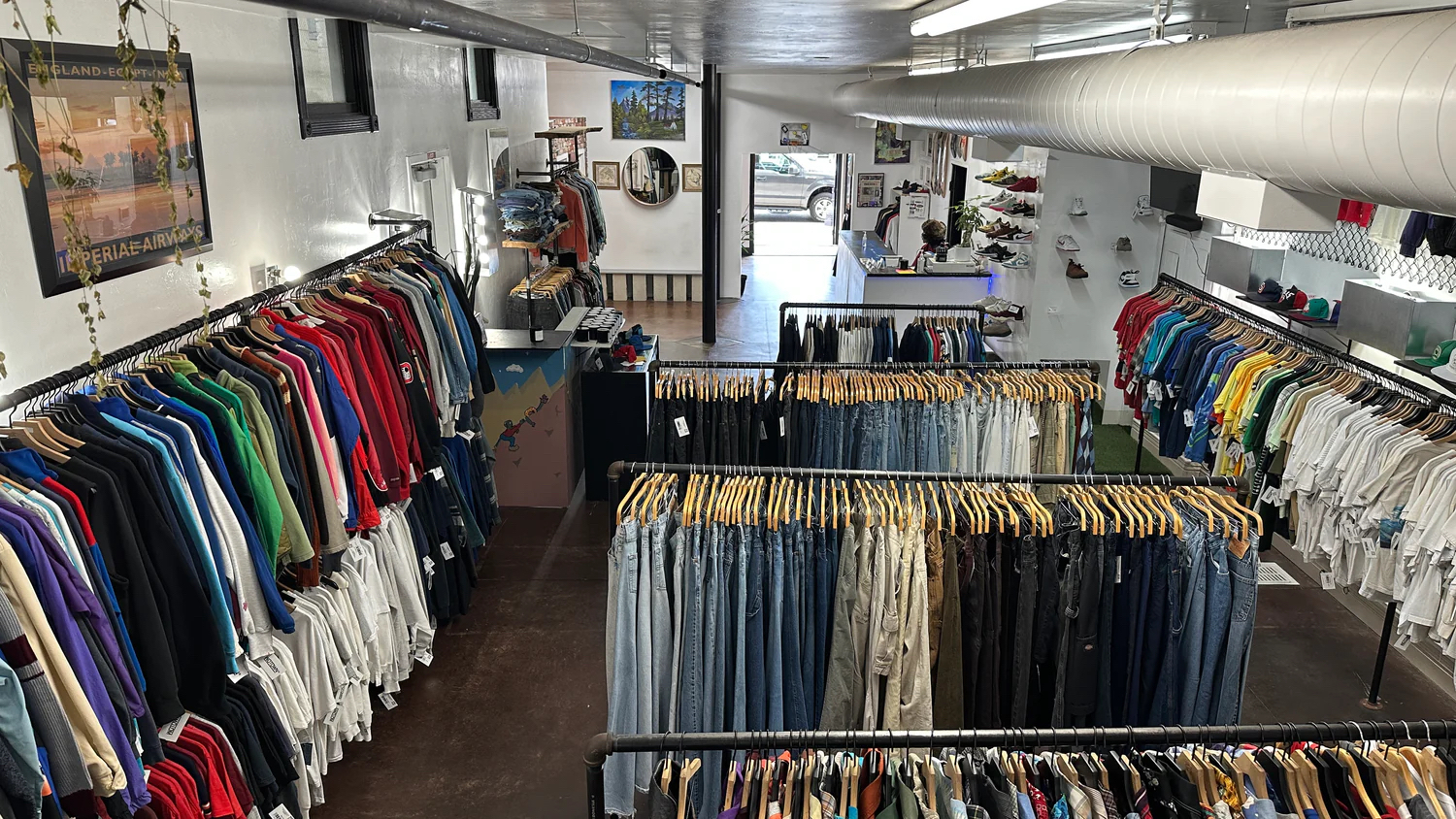 Interior of Wotwon Vintage thrift store in East Village, San Diego featuring racks of secondhand clothing, sneakers, and other collectibles