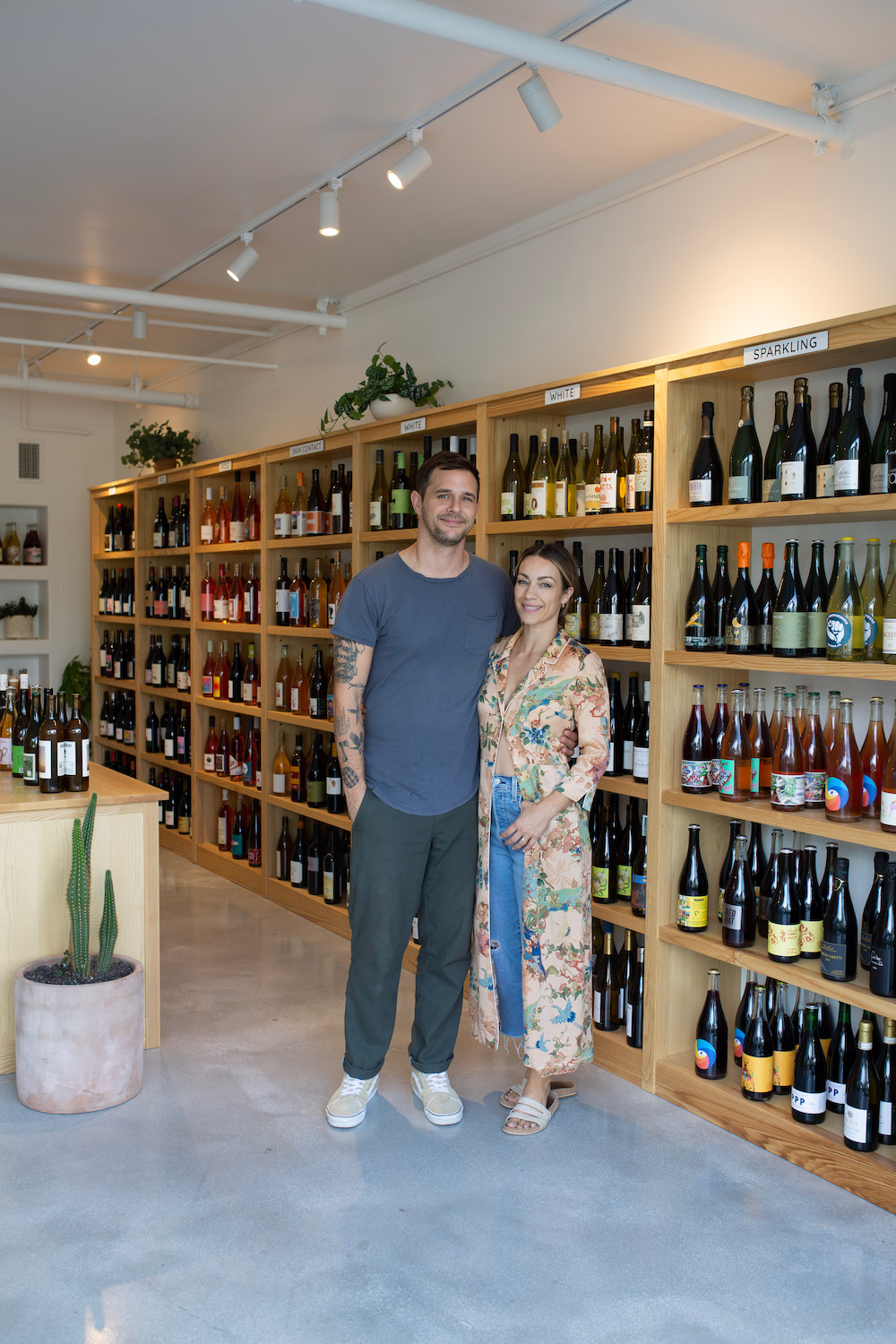 Founders standing infront of wine racks at new natural wine bar Little Victory Wine Market, Jeremy Simpson and Kirsten Potenza, opening in Carlsbad 
