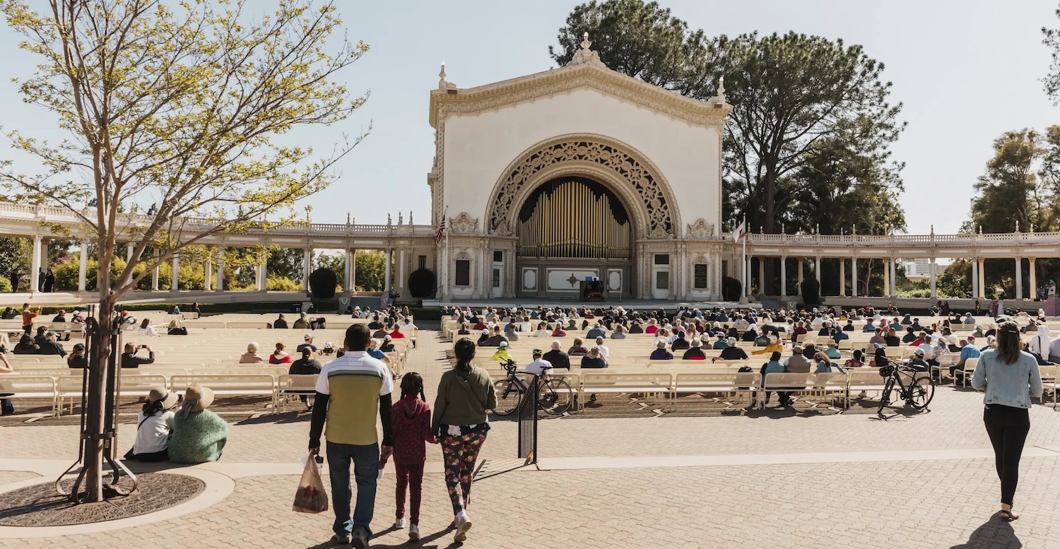 Family holding hands walking up to a free concert at Balboa Park's Spreckels Organ Pavilion in San Diego