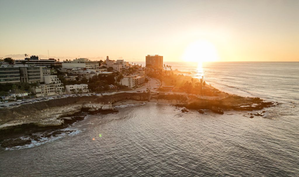 Aerial view of La Jolla Cove, a free thing to do with family, featuring sea lions and the ocean at sunset
