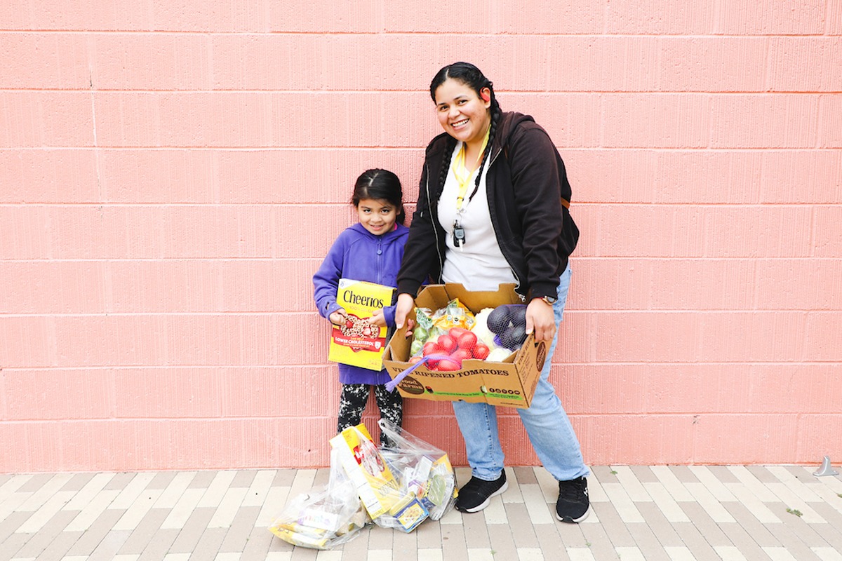 Mom and daughter holding box of food provided by San Diego nonprofit Feeding San Diego's food distribution programs