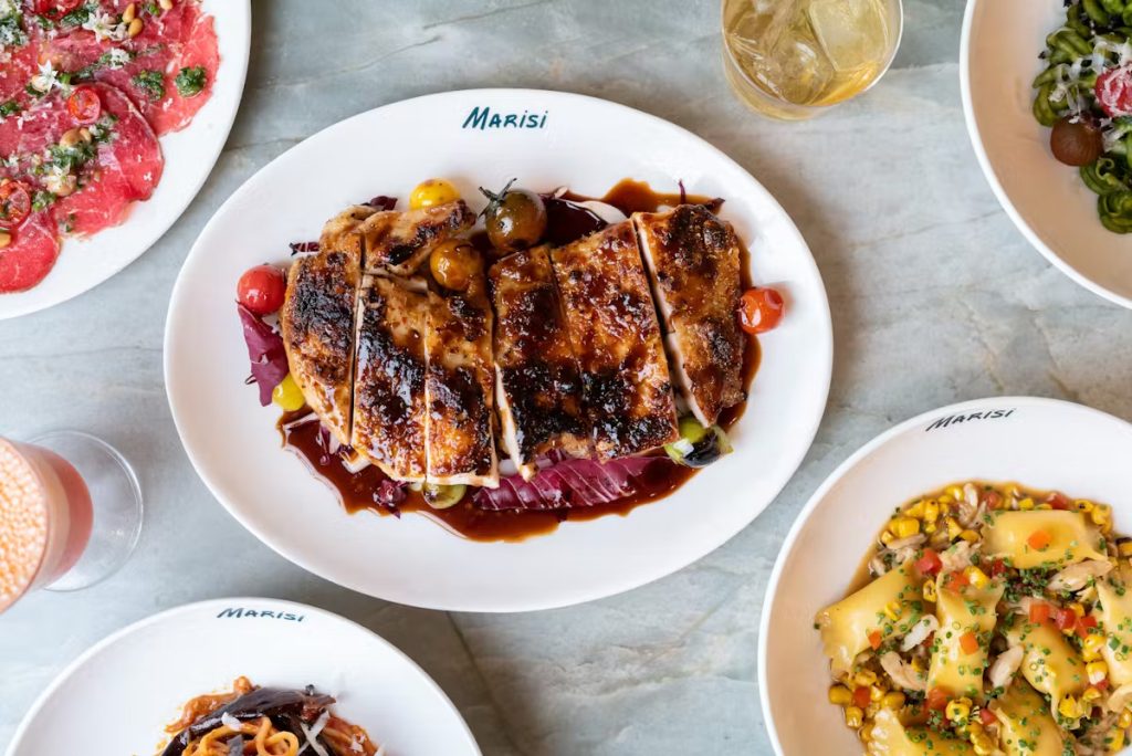 Food from San Diego restaurant Marisi now open for lunch in La Jolla featuring a plate full of food dishes and drinks