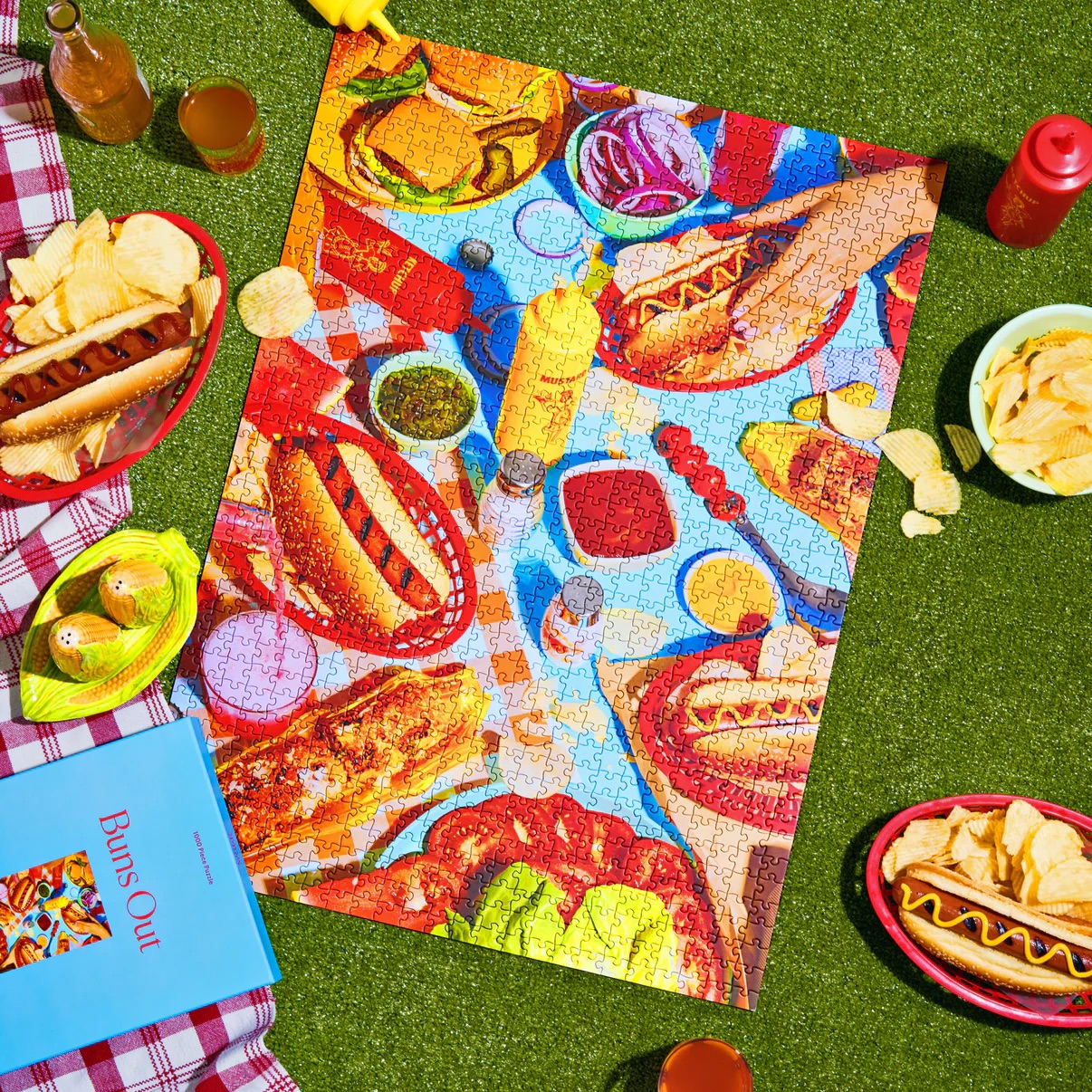 Buns out puzzle from Piecework Puzzles featuring an image of hot dogs and hamburgers on a picnic table
