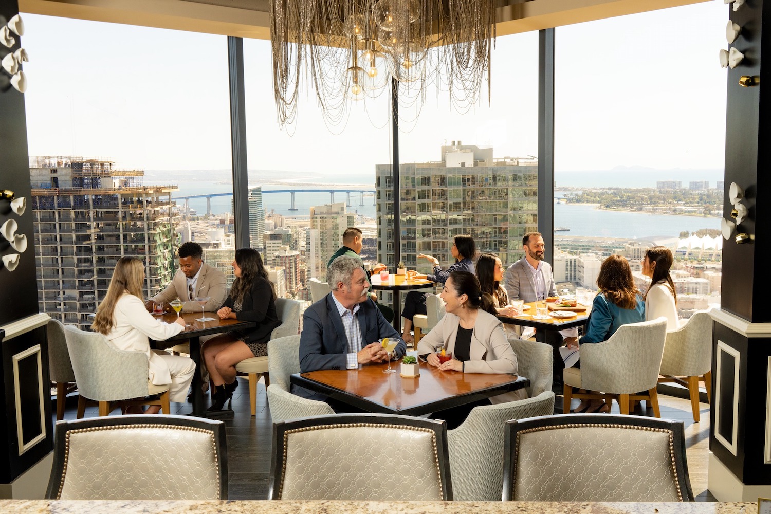 People dining at the University Club in Downtown San Diego featuring picturesque view of the city and Coronado bridge