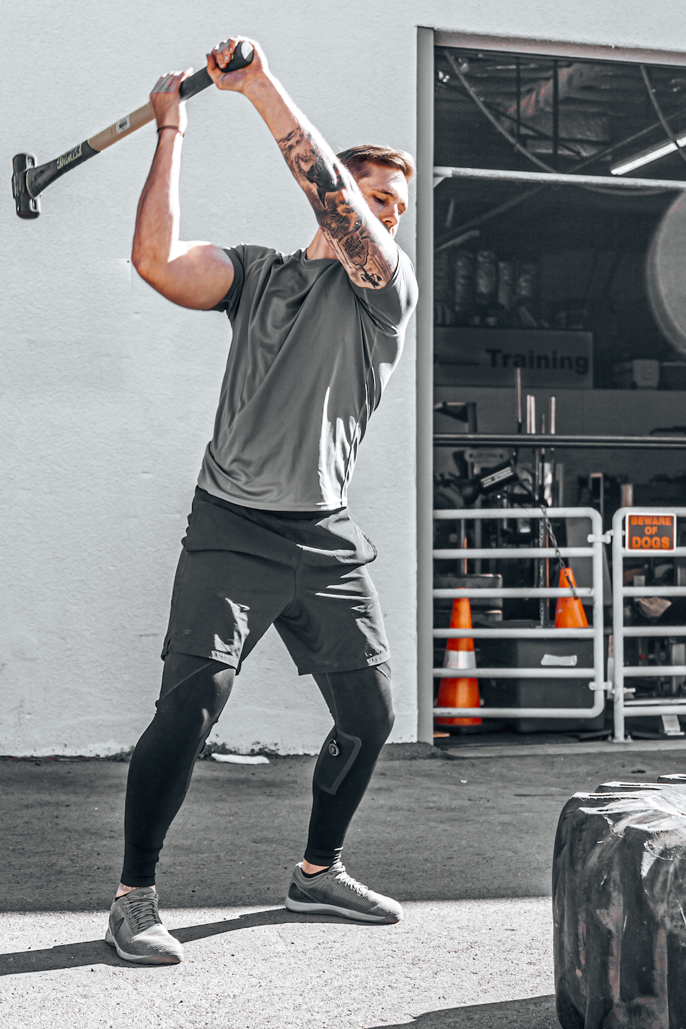 San Diego company Tighties Activewear featuring a man wearing athletic apparel swinging a sledgehammer at a gym