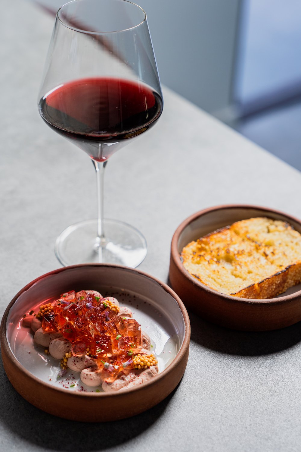 A seafood dish, bread, and wine from Hillcrest winebar and restaurant Cellar Hand