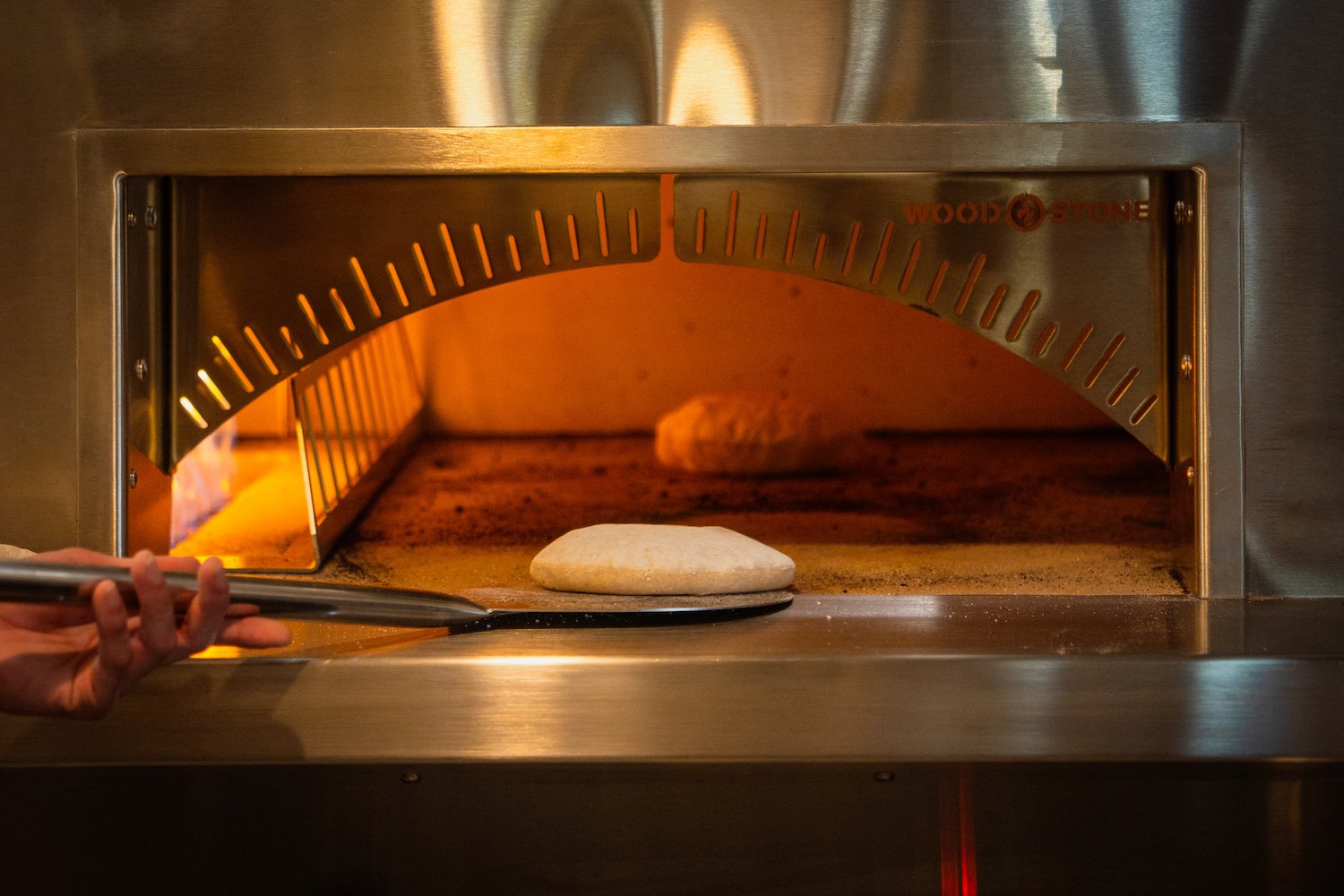A loaf of local-sourced bread enters the oven at Hillcrest winebar and restaurant Cellar Hand