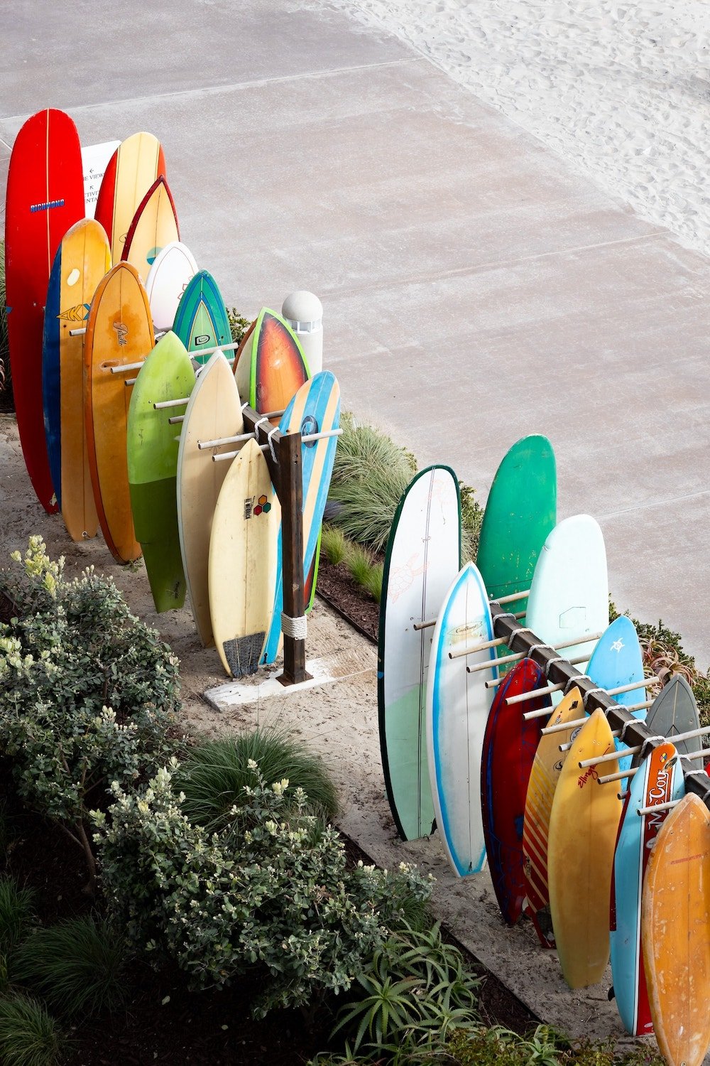 Exterior of the Hotel Del Coronado featuring a rack of surfboards for surf lessons