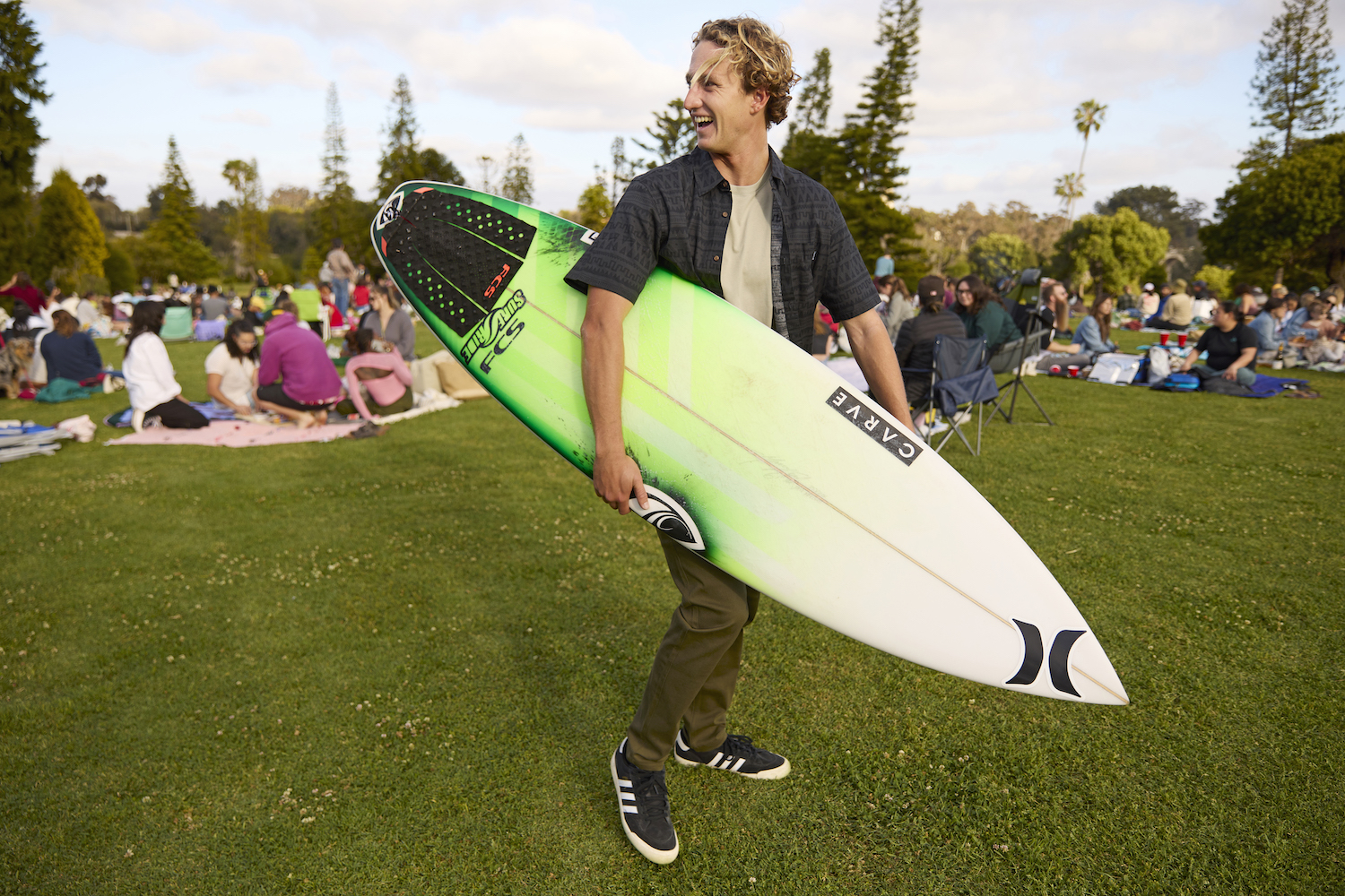 San Diego athlete and World Surf League pro surfer Jake Marshall holding his surfboard at Balboa Park