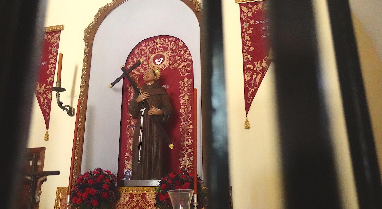 Interior of the San Sebastián Church in San Nicolás del Puerto in Servilla, Spain featuring a statue of Saint Diego holding a cross