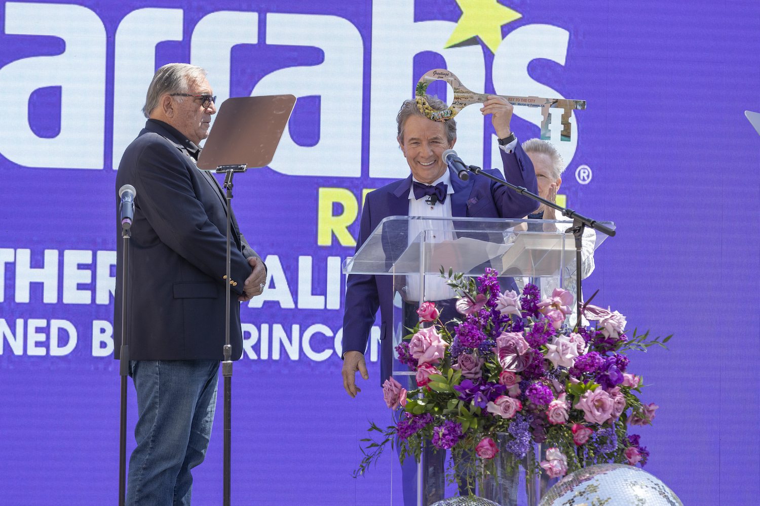 Mayor of Harrah SoCal's Funner, California Martin Short in a purple suit accepting the key to the city 