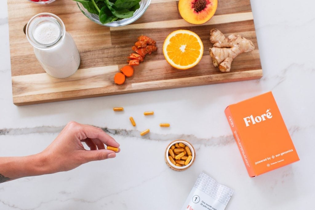 Custom Probiotics Floré supplement from San Diego company Sun Genomics featuring gut health supplement pills next to food