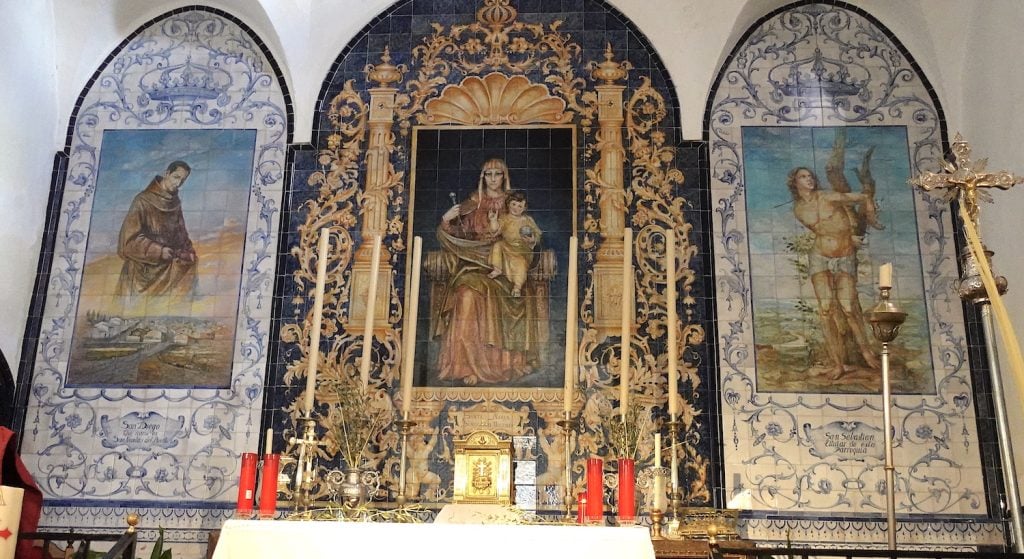 Interior of the San Sebastián Church in San Nicolás del Puerto in Servilla, Spain featuring tile paintings of Saint Diego and St. Francis of Assisi