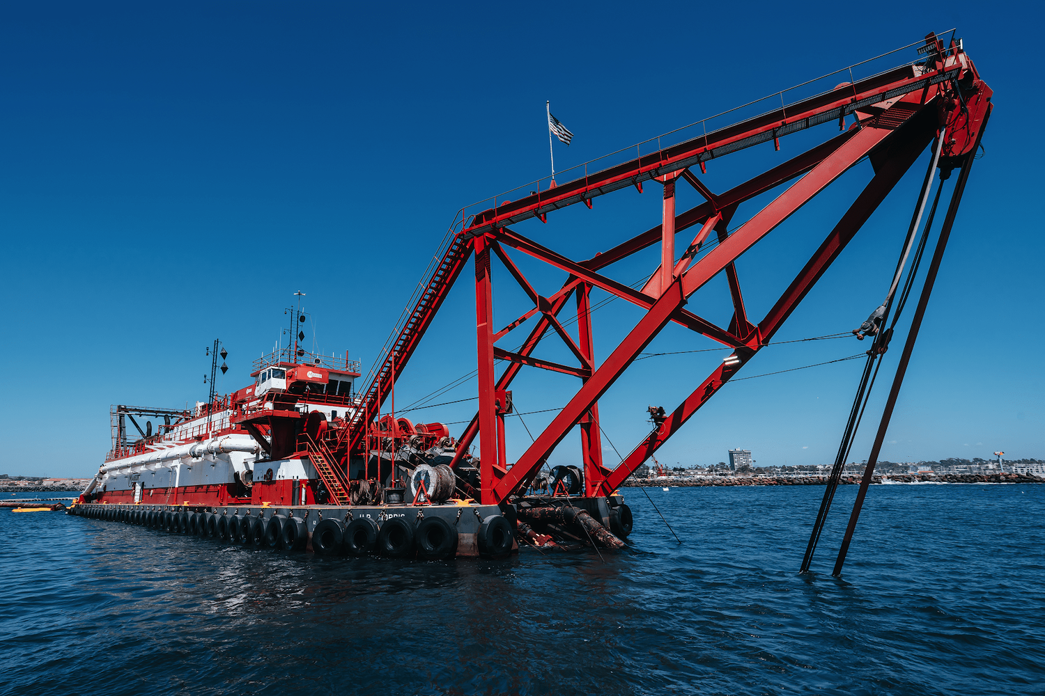 A large red sand dredging ship in San Diego based in Oceanside's harbor helping to compensate for erosion