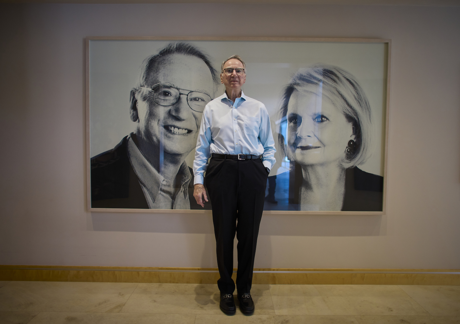 Irwin Jacobs, founder of Qualcomm, standing infront of a portrait of him and his wife Joan Jacobs