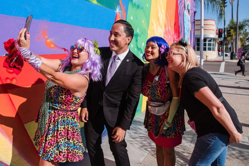 San Diego mayor Todd Gloria posing for pictures with LGBTQ+ people at the San Diego Pride Parade 