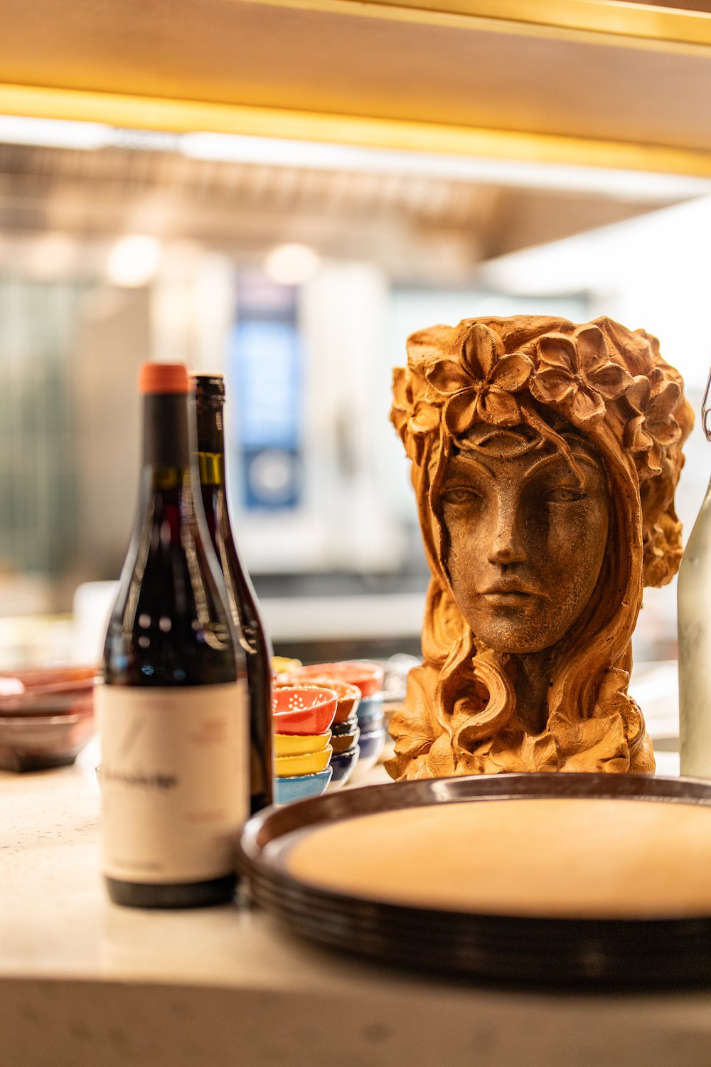 Interior of new San Diego tapas restaurant and wine bar Finca in North Park featuring a statue and wine bottles