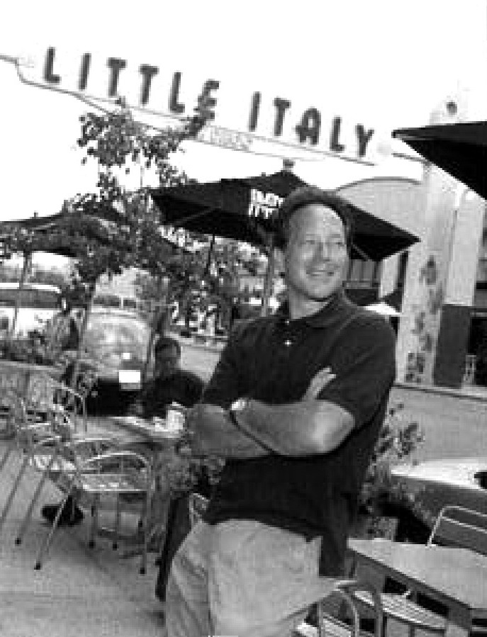 Photograph of New City America president Marco Li Mandri in front of the Little Italy sign