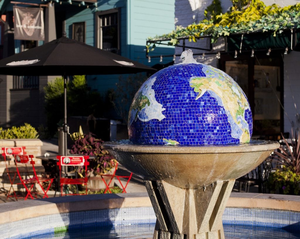 Exterior of San Diego's Little Italy plaza featuring a downtown space with a globe fountain