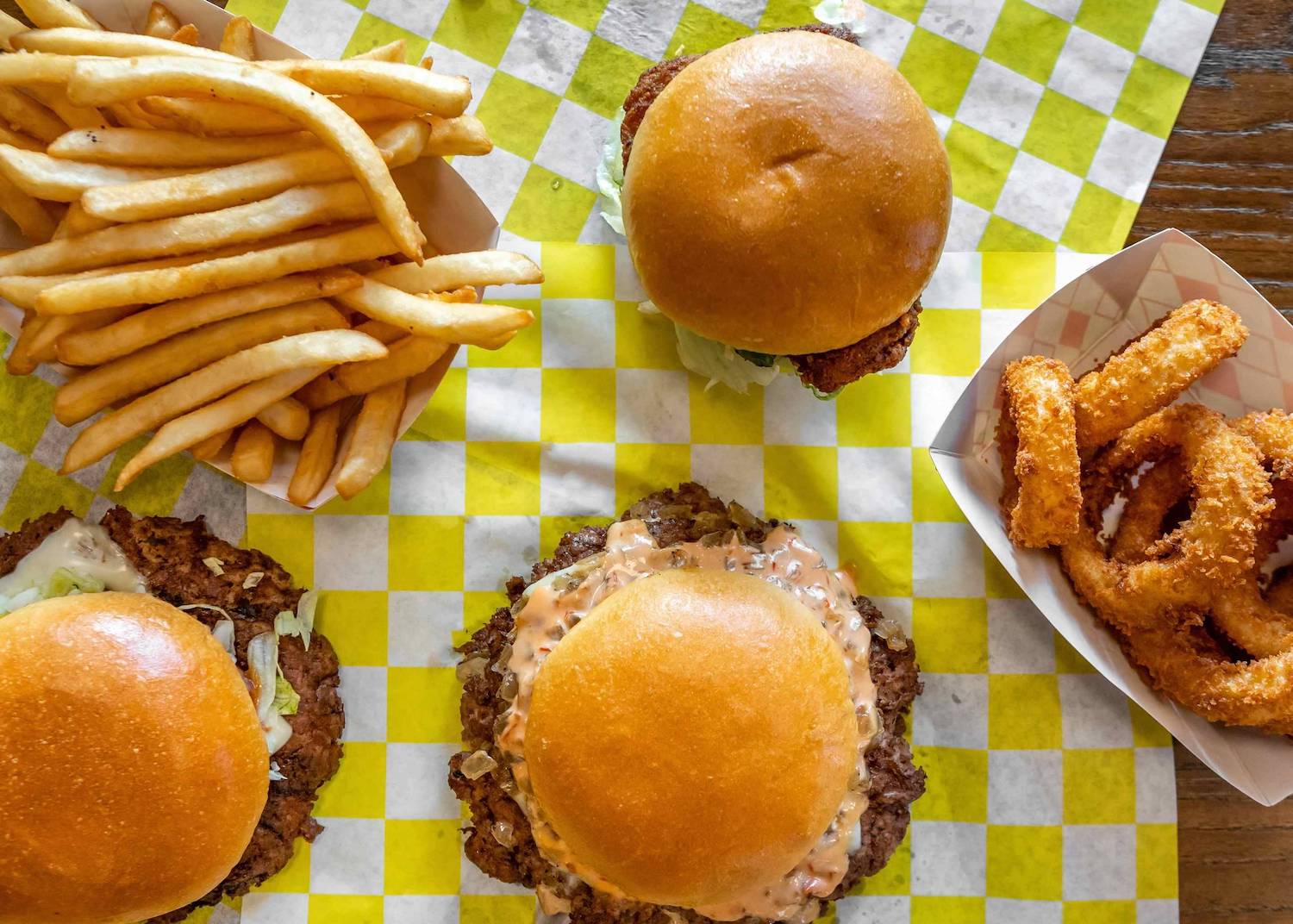 Food from San Diego fast food chain Eat Crispy Burger featuring burgers, fries, and onion rings