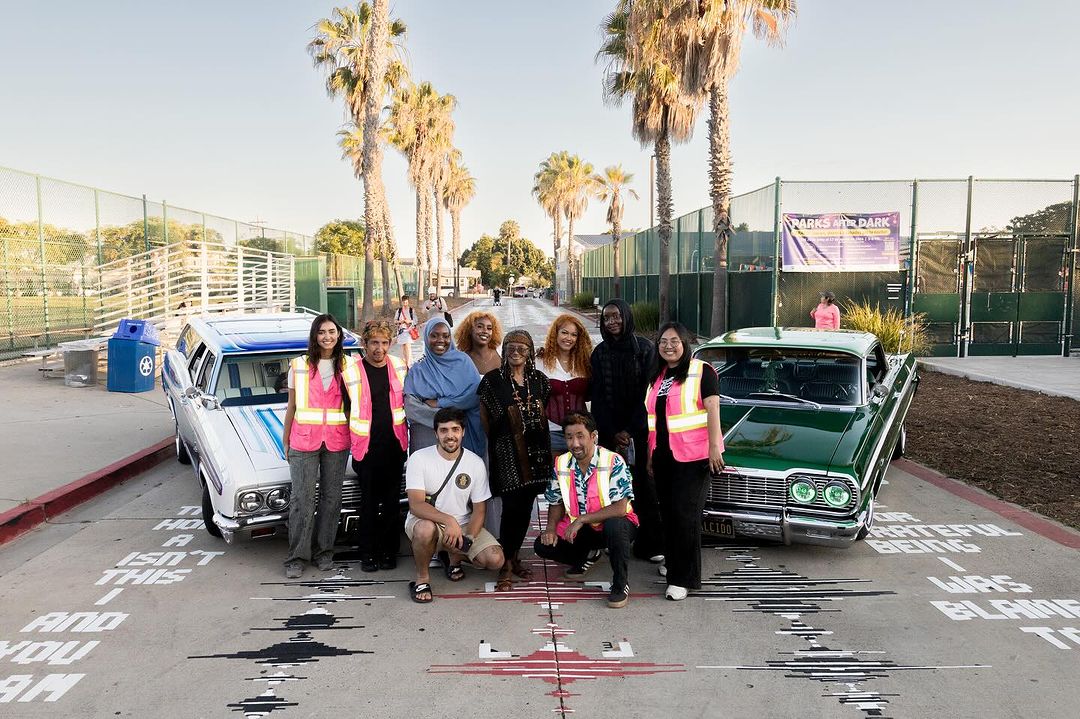 Shinpei Takeda and his team of poets and members of the AjA Project behind the new City Heights art installation Memoria Terra with lowrider cars and the poetry mural in the background