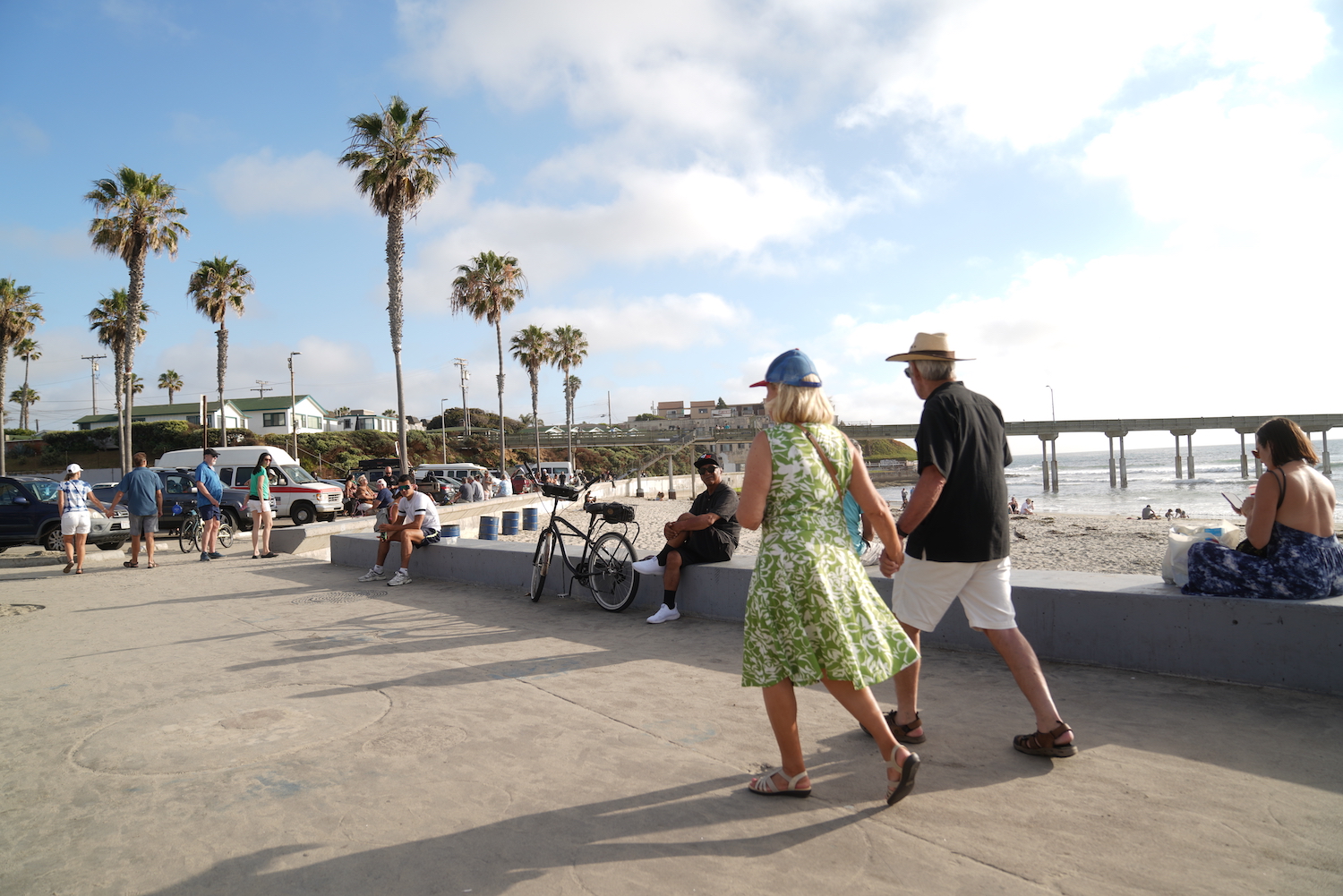 Two tourists walk on the Ocean Beach boardwalk towards the pier