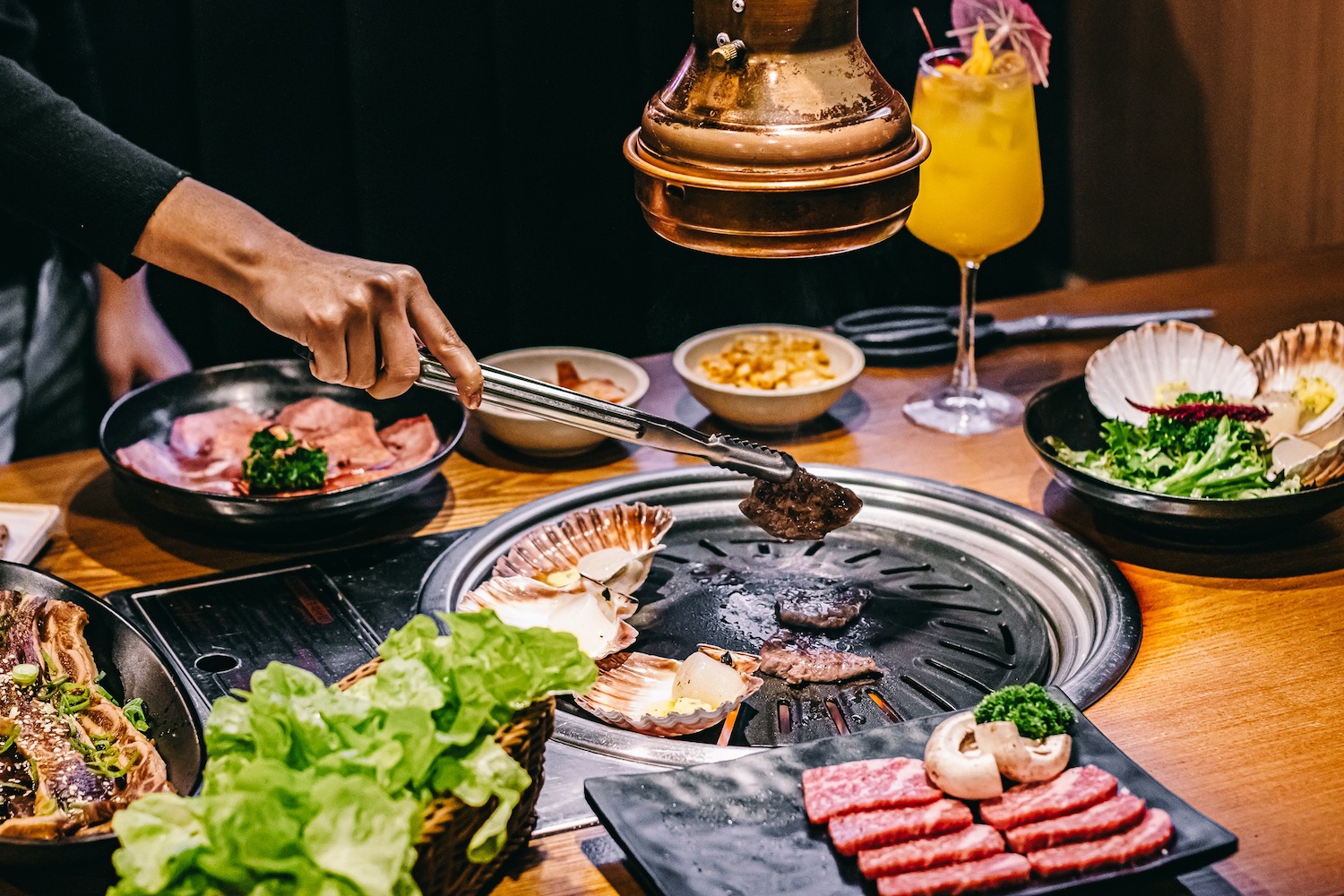 People grill meat at the new Korean restaurant “Sura Korean BBQ” in San Diego