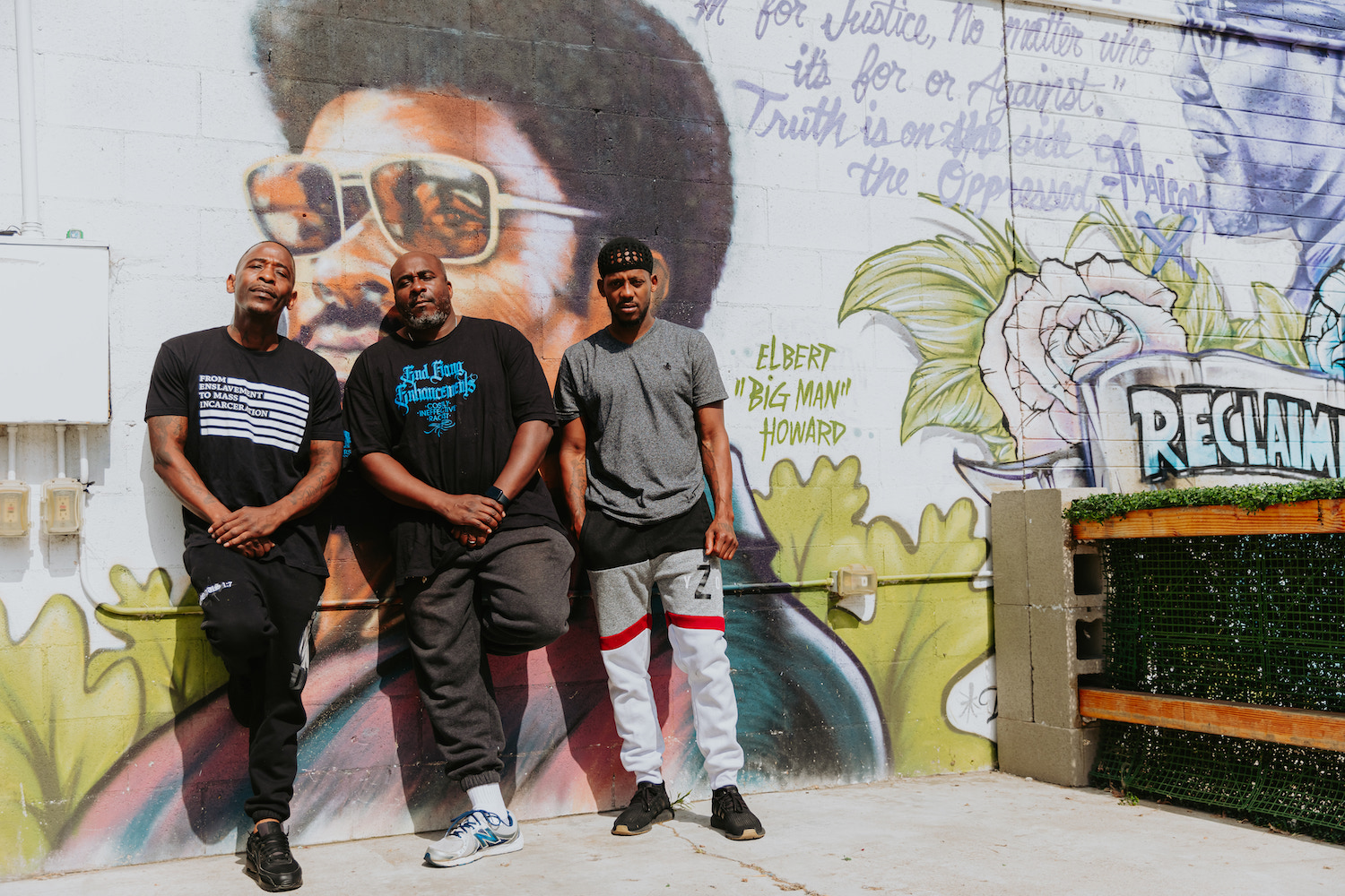 Founders of San Diego barbershop Imperial Avenue’s World Famous Imperial Barbershop in Encanto in front of mural