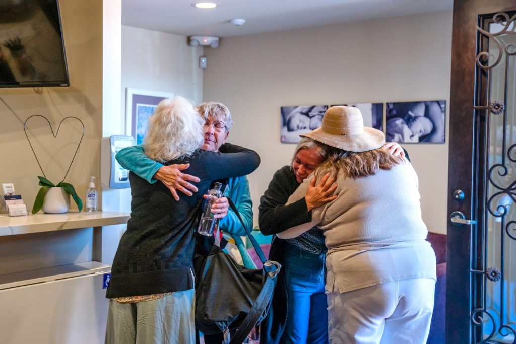 Executive Director Karen Rosalie hugs Kendra Wyatt, while Founder Roberta Frank hugs  Jolene Wyatt at the Best Start Birthing Center in San Diego on March 20, 2024. Kendra Wyatt had one birthing center location close down in Kansas City. 