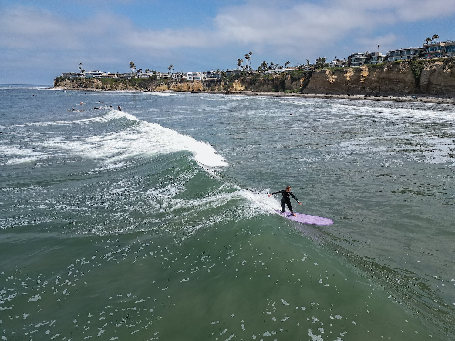 San Diego Wahine Kai member Carla Verbrugghen catching a wave at Tourmaline Surf Park