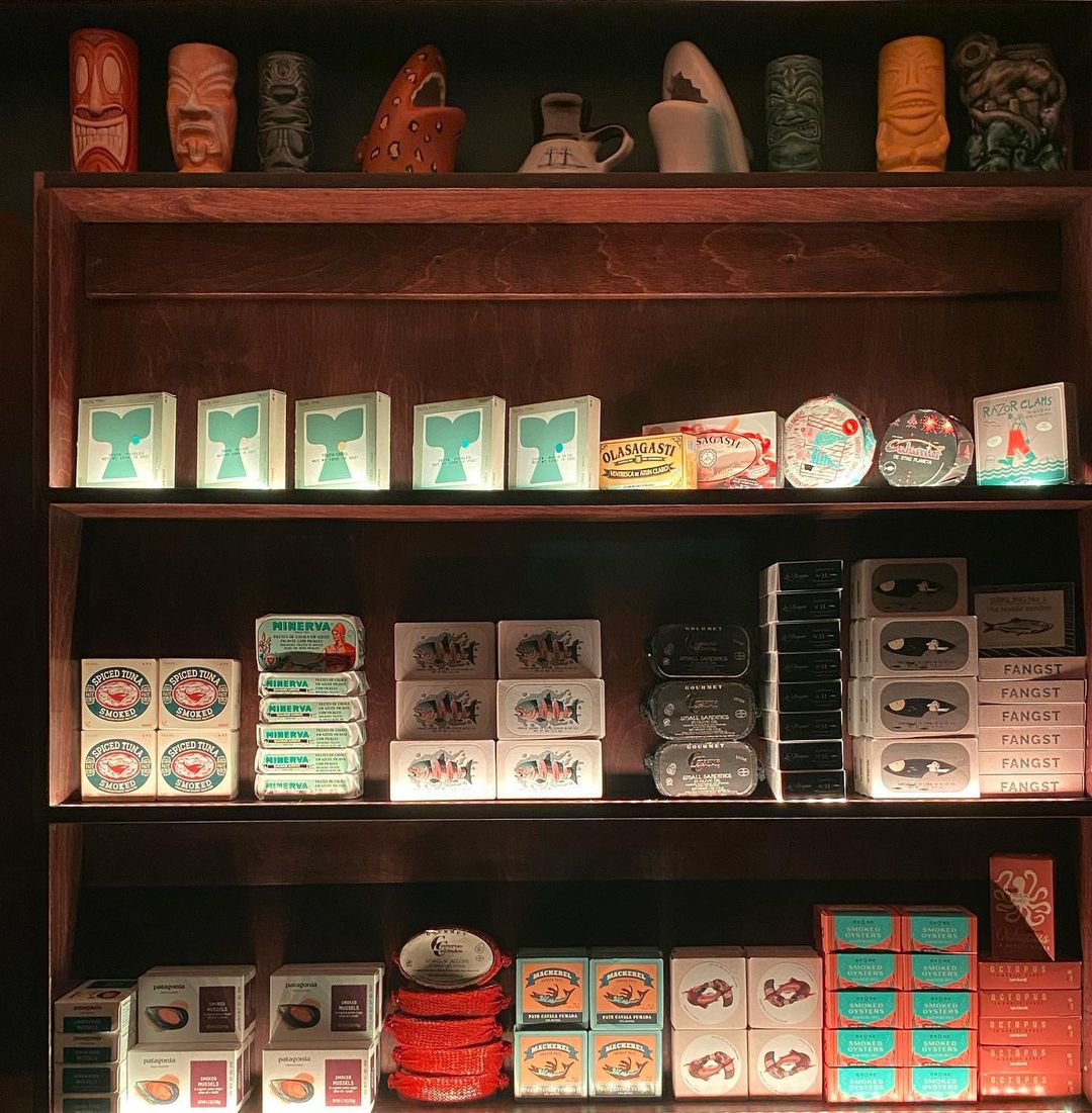 Cans of sardines on a shelf from San Diego seafood restaurant Oslo Sardine Bar opening in Jacumba