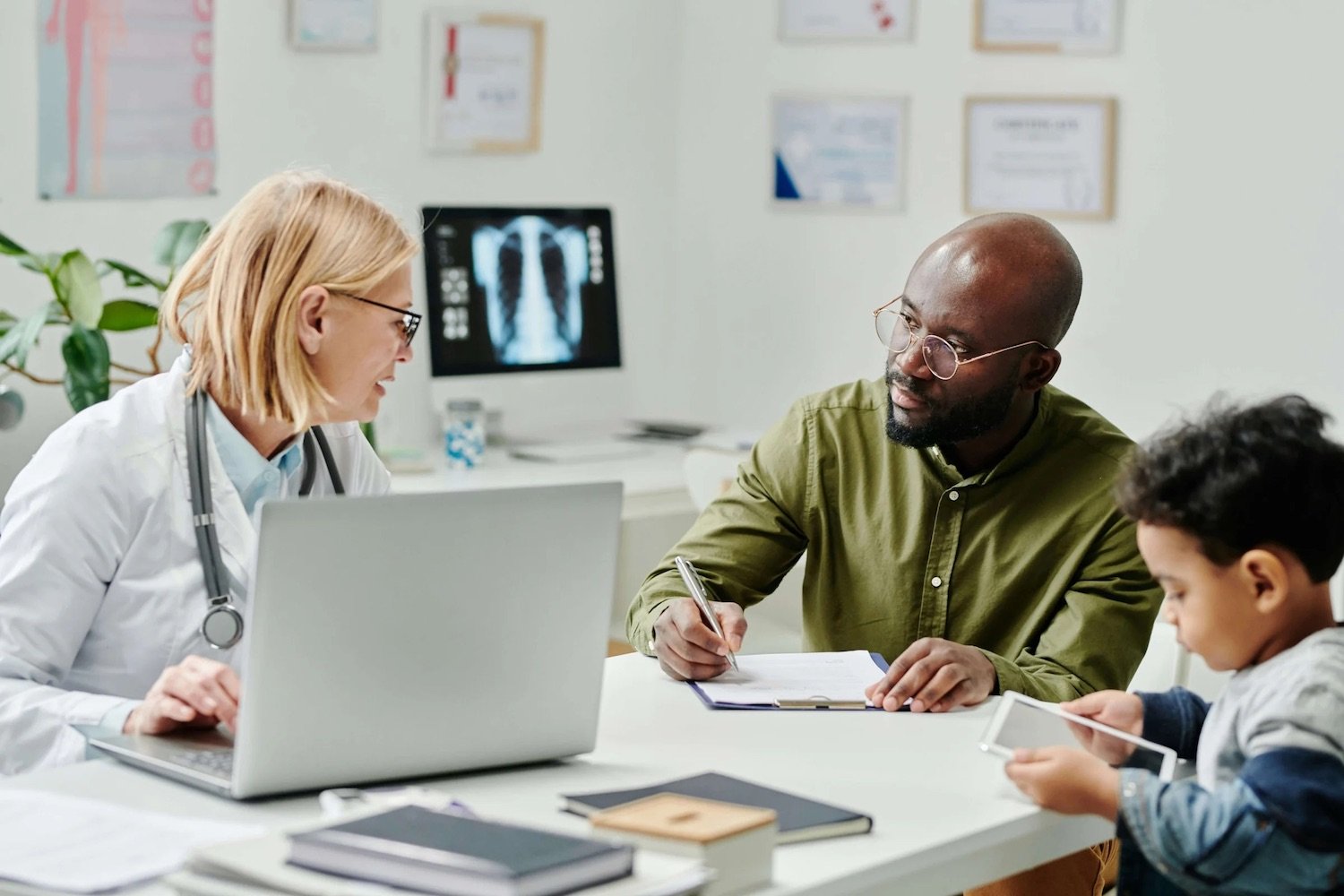 A man and his son talking with a doctor about San Diego Company Fore Genomics which provides health screenings to predict the health of children