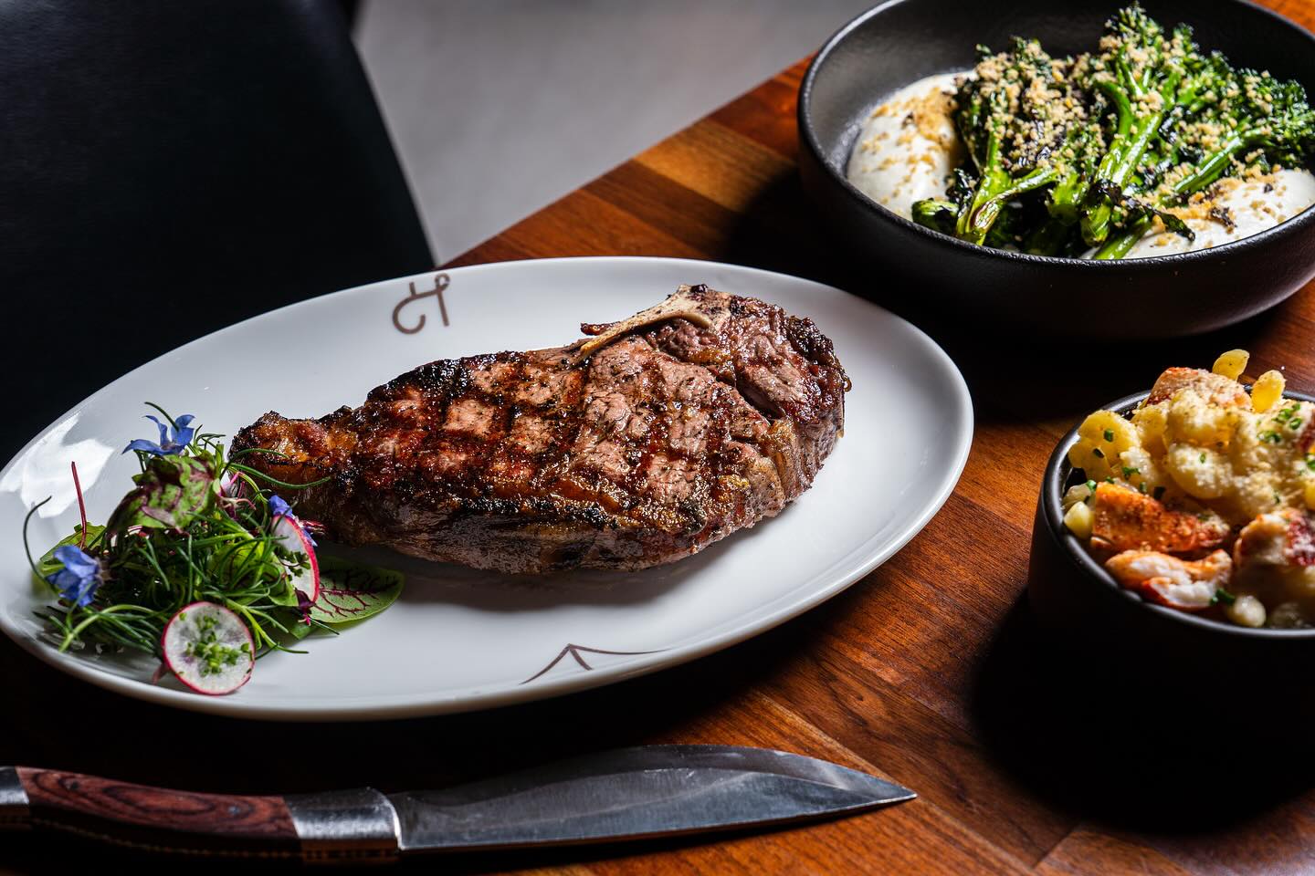 Best San Diego steak restaurants featuring a steak dish, greens, and macaroni from Huntress in the Gaslamp Quarter