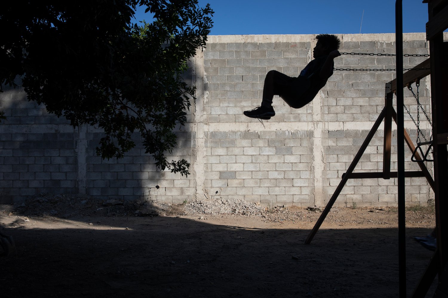 A young boy swings at EUNIME Por Tijuana ophanage for children with HIV/AIDS in Tijuana, Mexico