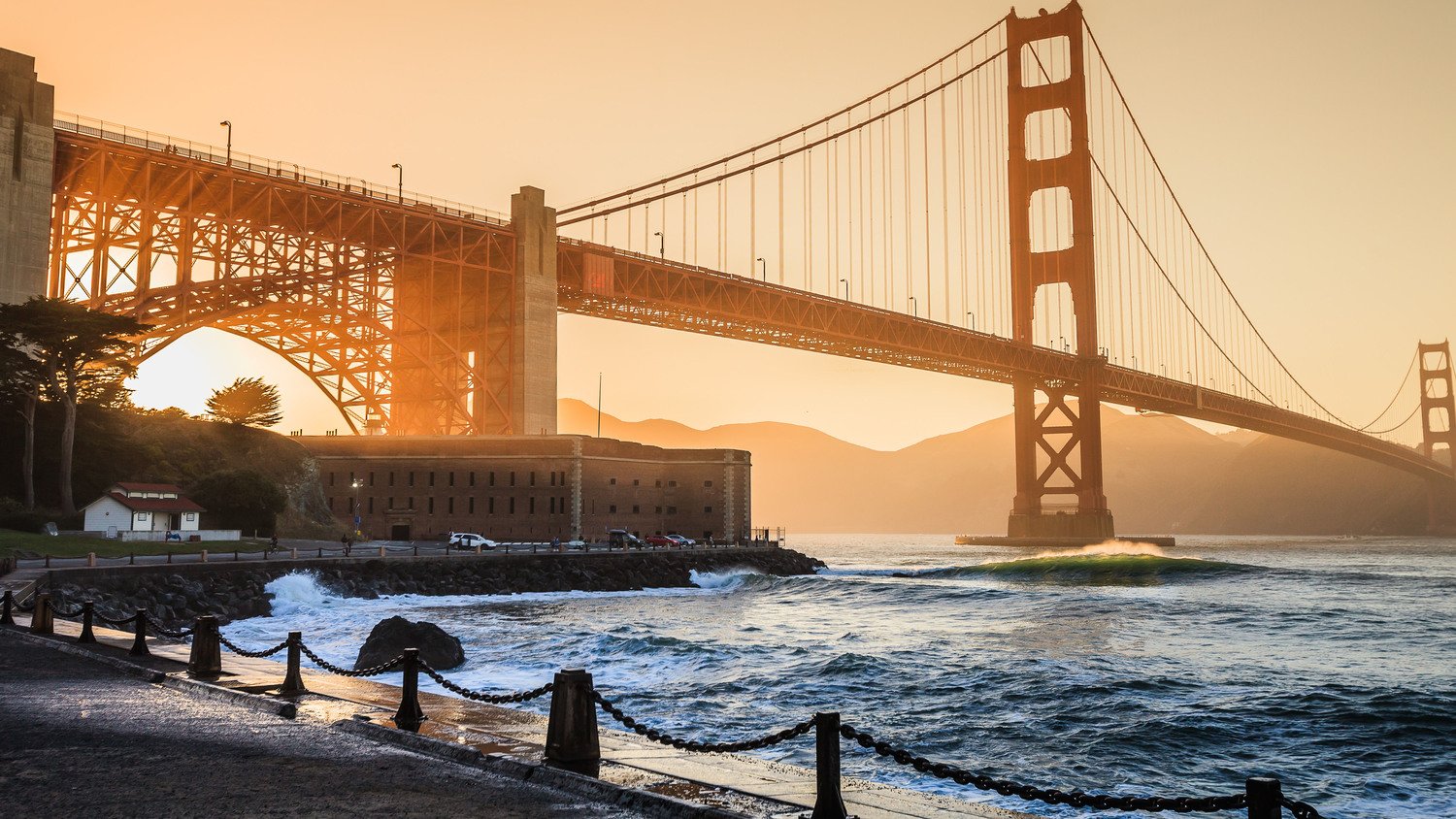 Best California surf spots featuring a wave at Fort Point in San Francisco with the Golden Gate Bridge in the background