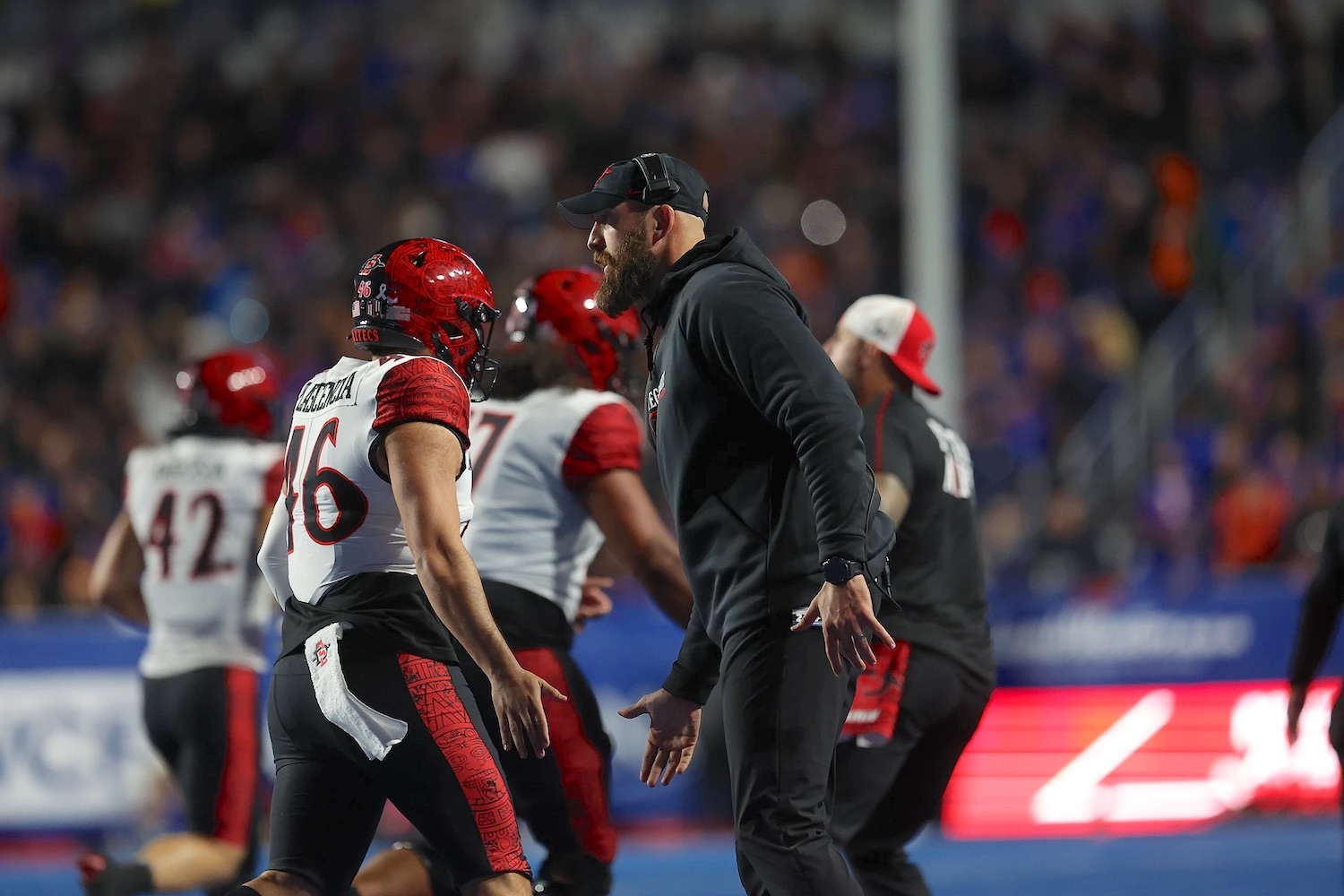 San Diego sporting events to watch this month November 2024, featuring 
San Diego State Aztecs Men's Football team featuring coach Sean Lewis and players on the sidelines