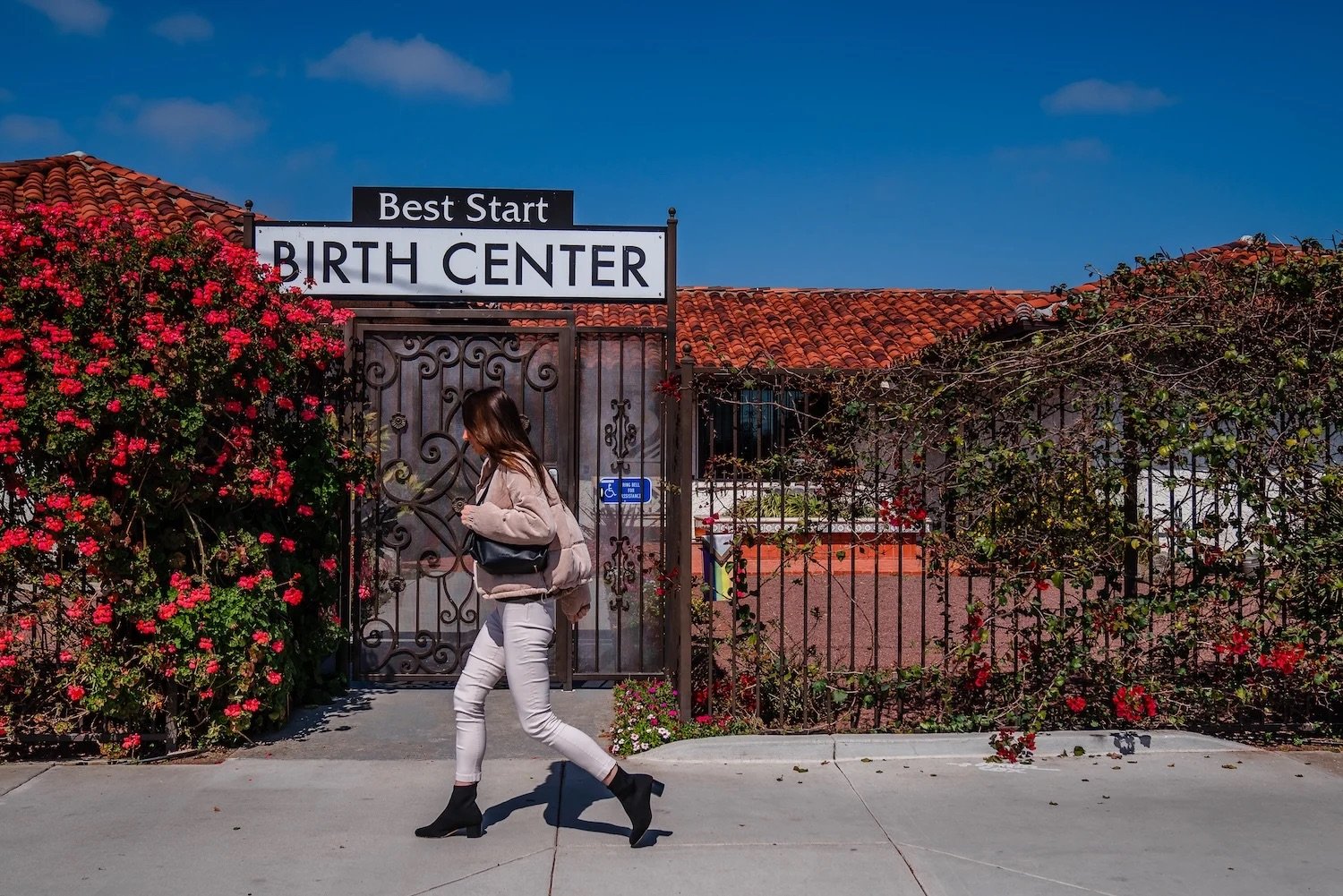 California birth center closures featuring a woman walking by a facility 