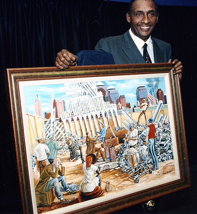 NFL player and painter Ernie Barnes standing with his painting 